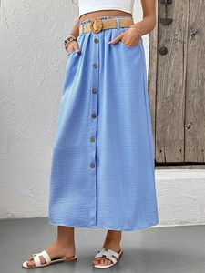Detail of light blue midi skirt featuring wood buttons, pockets and straw belt