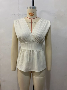 Détail du chemisier sans manches à col en V avec taille élastique et ourlet à volants