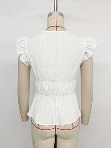 Detail view of the pleated white peplum top showing back ruffles and textured fabric