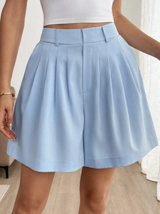 Dettaglio degli shorts a vita alta a pieghe blu chiaro con gamba larga e passanti cintura