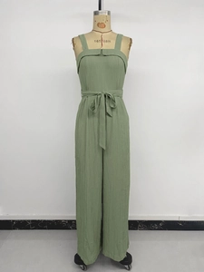 Detail of light green wide-leg jumpsuit with crepe texture and belted waist tie