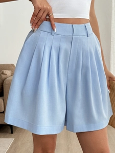 Dettaglio degli shorts a vita alta a pieghe azzurri con una silhouette svasata a trapezio