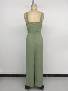 Detail of sage green jumpsuit showing back zipper and textured smocked fabric