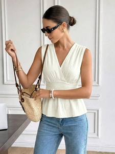 Détail du chemisier blanc sans manches à col en V avec une taille haute à basque