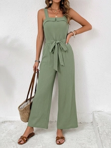 Detail of sage green sleeveless jumpsuit in textured cotton fabric with waist tie