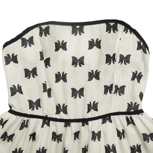 Détail de mini robe bustier Y2K avec imprimé nœuds noirs et bordure contrastée chic