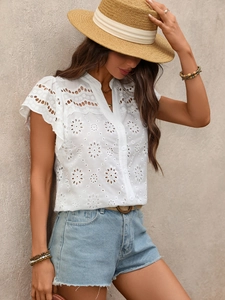 Detail shot of white eyelet embroidery and elegant lace texture on a V-neck shirt