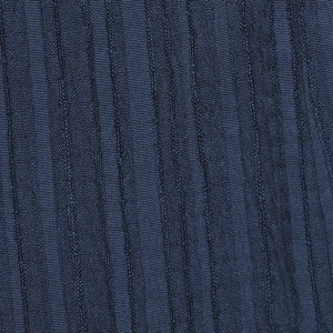 Dettaglio macro del tessuto intrecciato blu navy con trama a coste verticali e motivi a maglia