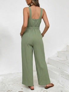Detail of sage green wide-leg jumpsuit showing back zipper and waist tie texture