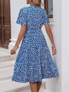 Rear view of a blue V-neck short sleeve dress with white print and tiered ruffle hem
