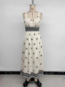 Detailed embroidery on cream sleeveless dress with black geometric patterns and stars