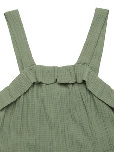 Detail of sage green jumpsuit featuring textured seersucker fabric and ruched square neckline