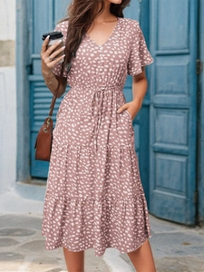Detail of V-neck short sleeve dress with floral print and tiered skirt layering