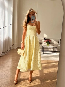 Détail d'une robe mi-longue sans manches en jacquard jaune pâle avec texture florale élégante