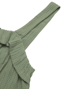 Macro shot of sage green waffle fabric texture and stitching on sleeveless jumpsuit