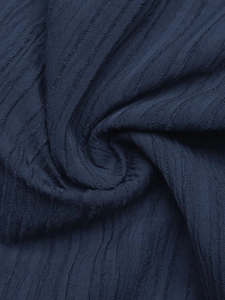 Dettaglio del tessuto a costine blu navy con texture verticale e morbido drappeggio