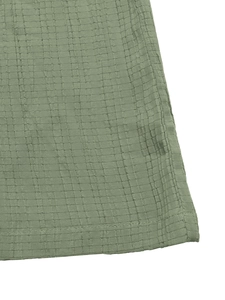 Close-up of sage green waffle textured fabric with neat double-needle hem stitching