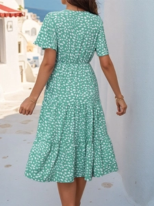 Back view of a tiered green dress with white prints, perfect for summer vacations