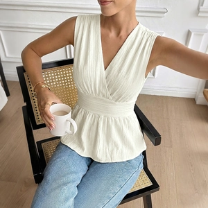Élégante blouse beige sans manches à col en V, taille cintrée et tissu texturé chic