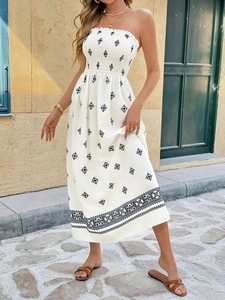 Detailed view of bohemian white tube dress featuring black star embroidery and floral lace hem