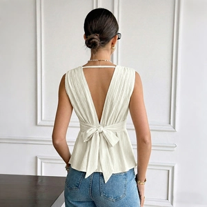 Élégante blouse blanche sans manches dos nu avec col en V, tissu texturé et grand nœud dos