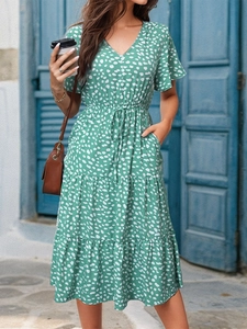 Detail of green floral summer dress with V-neckline and tiered ruffle skirt