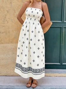Detail of smocked strapless bodice and navy geometric print on a white maxi dress