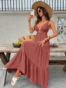 Close-up of rust red tiered maxi dress featuring a deep V-neck and smocked texture fabric