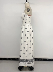 Detail view of smocked bodice and ethnic embroidery on white strapless long dress