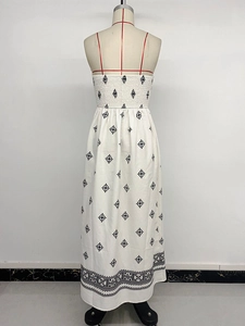 Detailed view of bohemian floral print and textured fabric on strapless white maxi dress