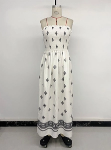 Detail of white cotton strapless maxi dress featuring black geometric print and smocked bust