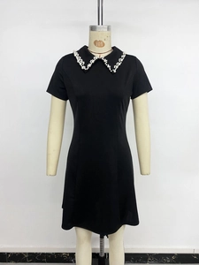 Detail of elegant black dress showing Peter Pan collar with hand-stitched white pearls