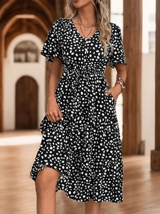 Detail view of V-neckline and black and white polka dot print on a summer midi dress