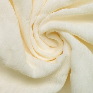 Macro detail of creamy white seersucker fabric texture with soft pleated design