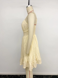 Detail view of yellow smocking waist and textured seersucker fabric on mini dress