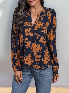 Detailansicht des V-Ausschnitts einer langärmeligen blauen Blumenmuster-Bluse