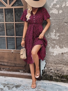 Detail of V-neck tiered dress with leopard print, drawstring waist, and button front design