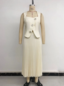 Detail view of cream two-piece set featuring a buttoned sleeveless top and pleated skirt