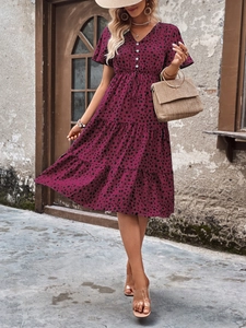 Close-up of a burgundy V-neck summer dress with black polka dots and waist drawstring