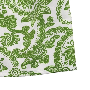 Detailed close-up of green Paisley print on white fabric with fine stitching