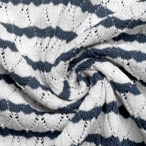 Detailed macro view of blue and white wave pattern knit fabric with pointelle eyelets