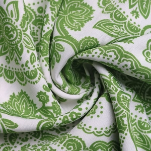 Detail shot of green Paisley print fabric with rich cotton texture and floral patterns