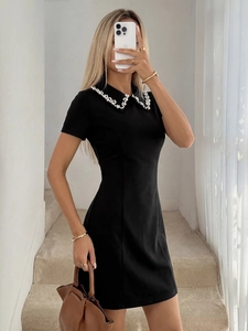 Detailed view of the beaded Peter Pan collar with pearls on a black mini T-shirt dress