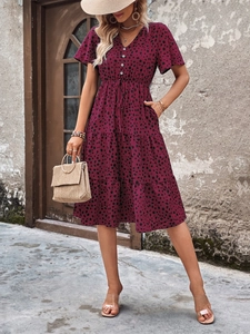 Detail of V-neck tiered polka dot dress with adjustable drawstring waist and buttons