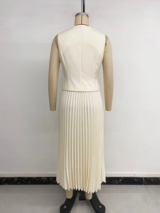 Detail view of the beige sleeveless top and pleated maxi skirt set back texture