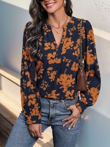 Detail der langärmeligen V-Ausschnitt Bluse mit elegantem orangefarbenem Blumendruck