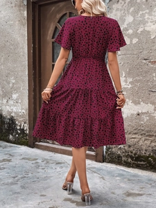 Rear view of wine red tiered midi dress with polka dots and short sleeves