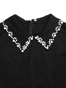 Detail of black dress collar with white faux pearl beads and invisible zipper