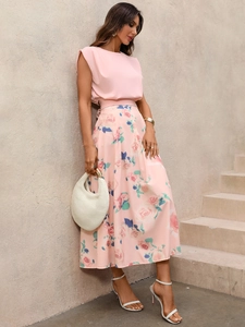 Détail du haut sans manches rose et jupe longue à imprimé rose avec sac à main tissé