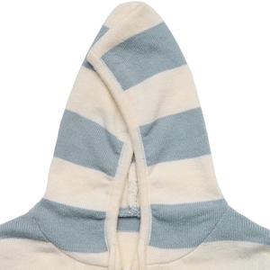 Détail de la texture en maille à rayures bleues et beiges sur un cardigan à capuche